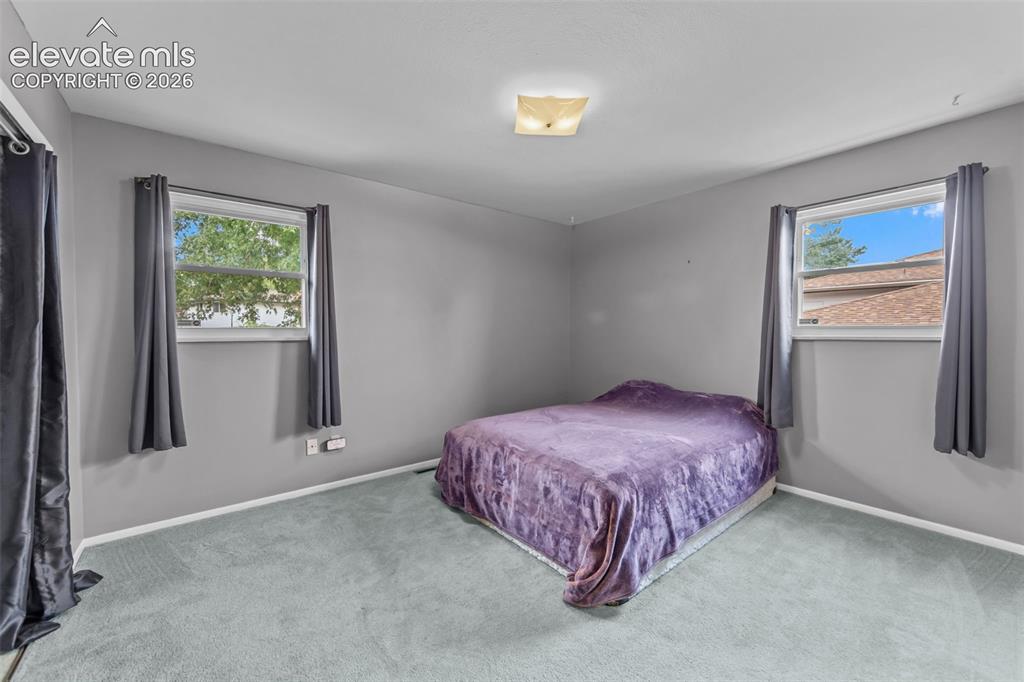 Image 12 of 35: Carpeted flooring with painted walls, featuring a ceiling-mounted light fix