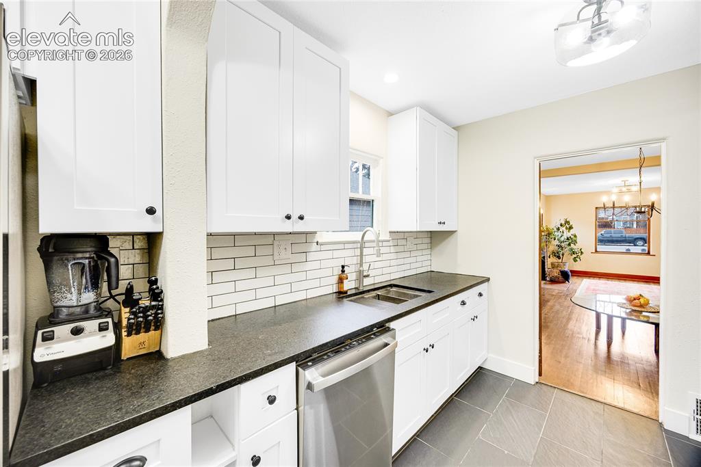 Image 10 of 33: Kitchen featuring white shaker cabinetry, stainless steel appliances, leath
