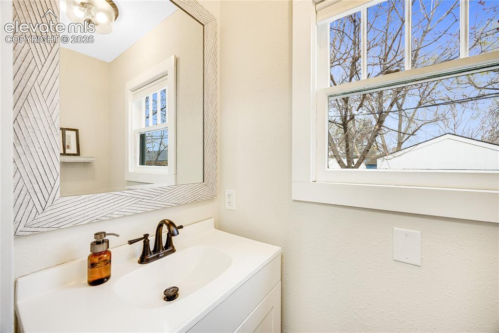 Image 11 of 33: Half Bathroom - Vanity with integrated sink, matte black-finish faucet, and