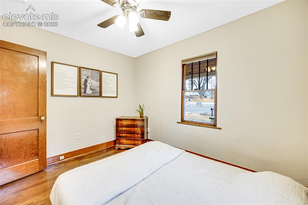 Image 13 of 33: Wood-finish flooring, light-toned walls, ceiling fan with light fixture, an