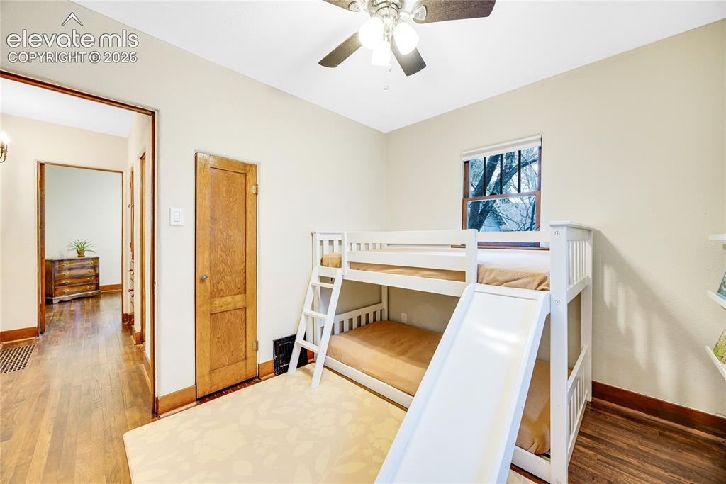 Image 15 of 33: Hardwood flooring, natural wood doors, and a ceiling fan with integrated li
