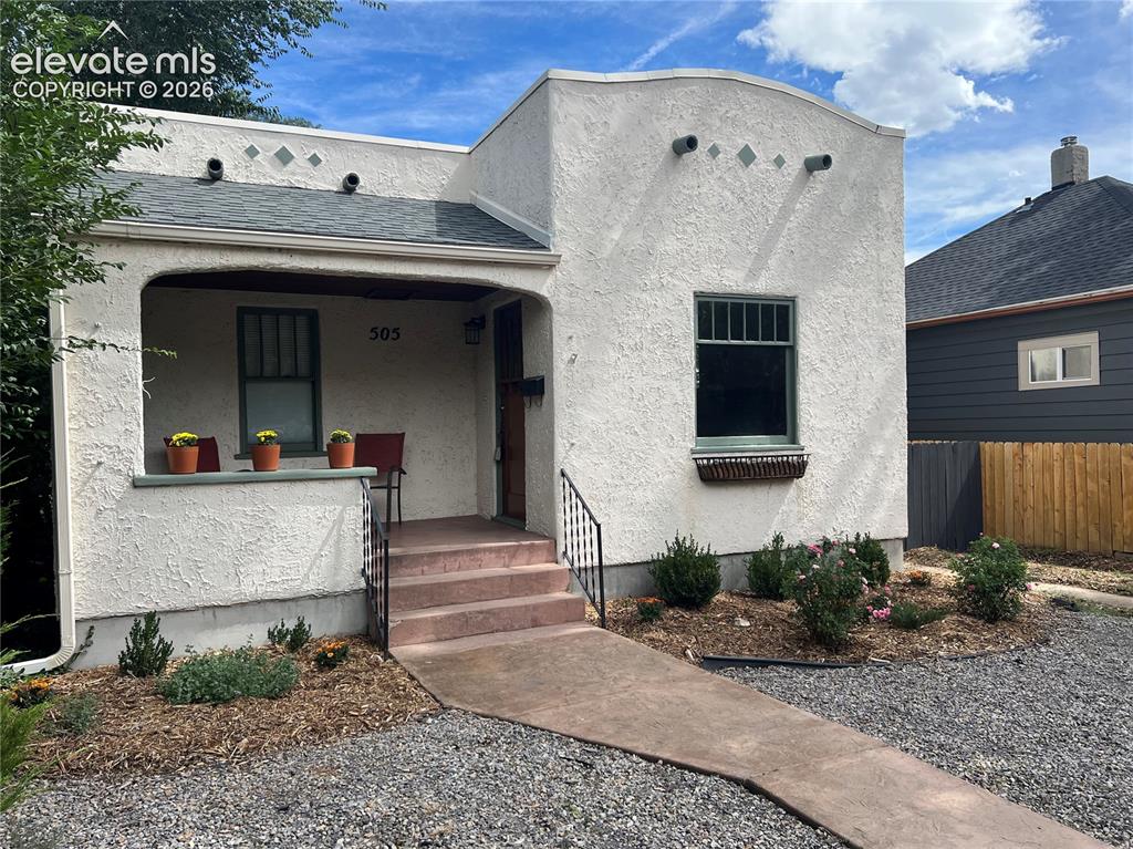 Image 2 of 33: Stucco exterior with an arched entryway and covered porch