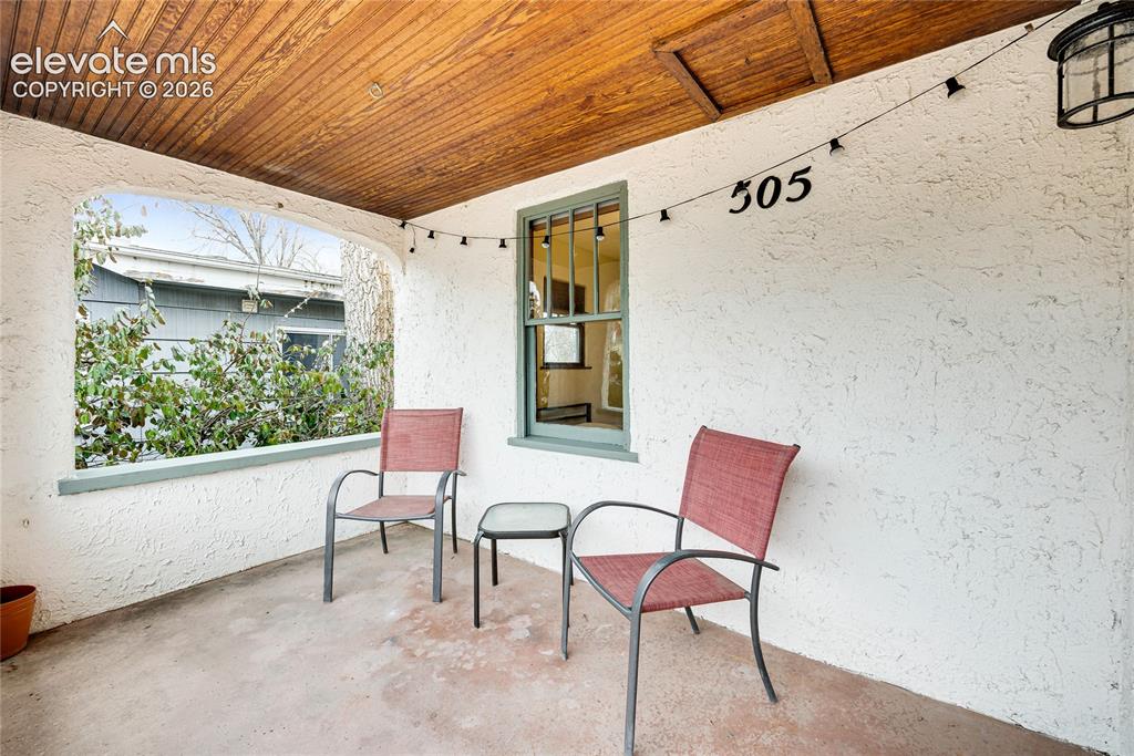 Image 3 of 33: Covered front porch featuring a wood-panel ceiling, textured stucco walls, 