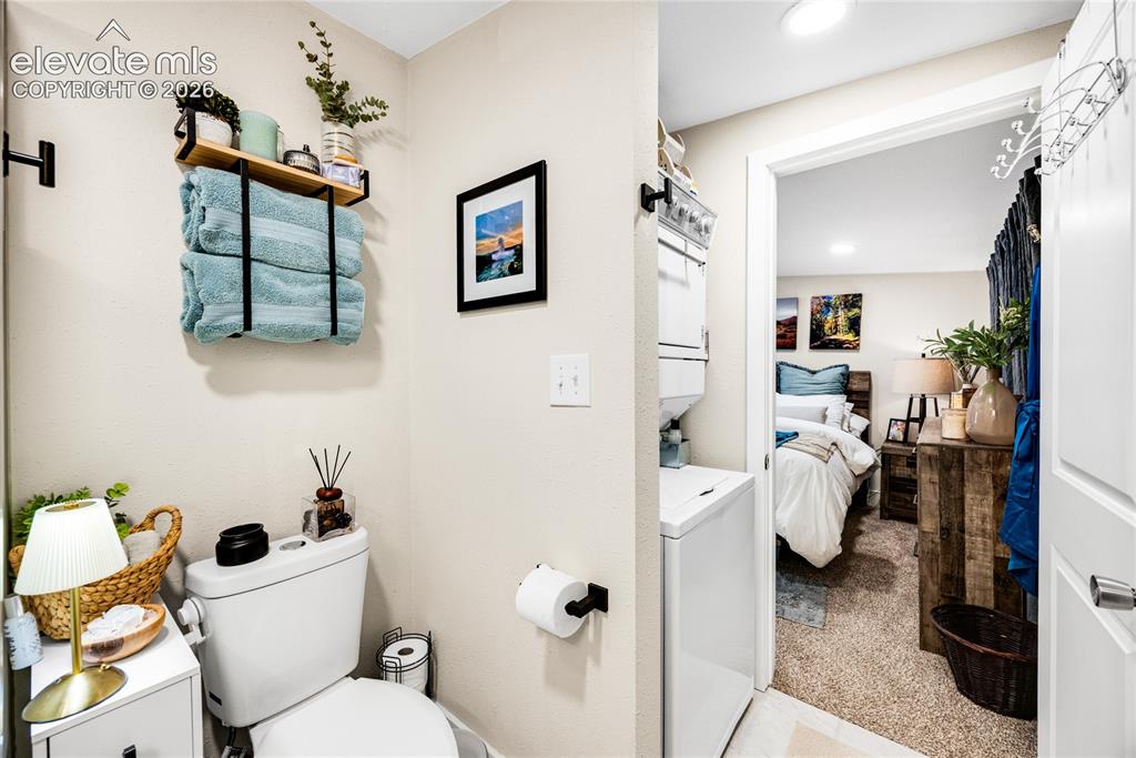 Image 31 of 33: ADU/Cottage - White toilet with a built-in shelving unit, a wall-mounted wo
