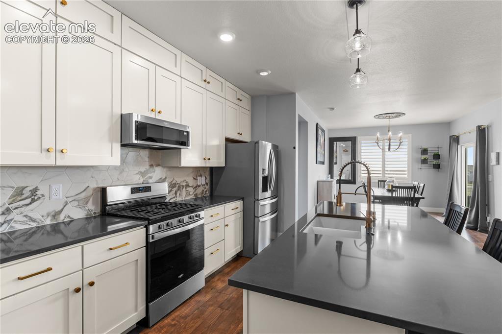 Image 13 of 41: Quartz countertops, a pantry, upgraded appliances and gas range, upgraded l