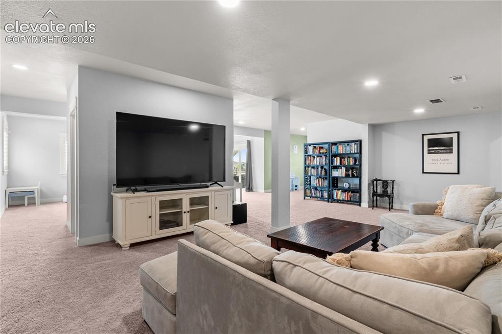 Image 25 of 41: The basement is truly a retreat. The walkout fills it with natural light a