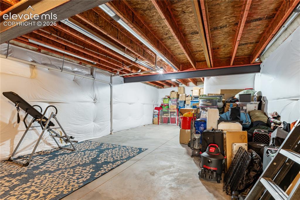 Image 31 of 41: Unfinished storage area with custom barn door.