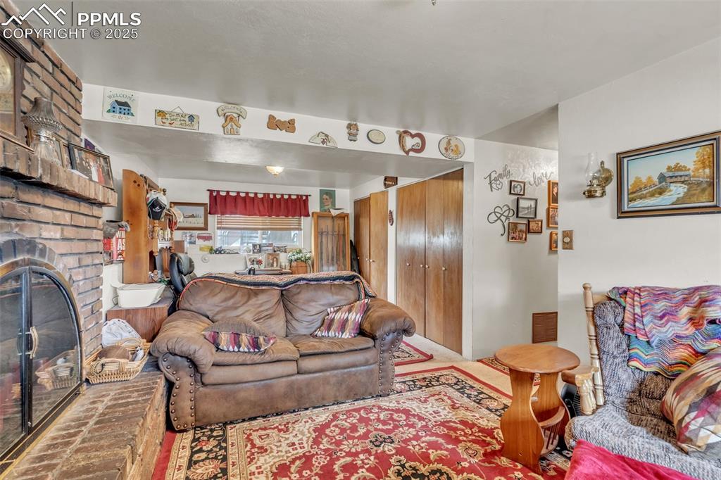 Image 10 of 49: Living area featuring a brick fireplace