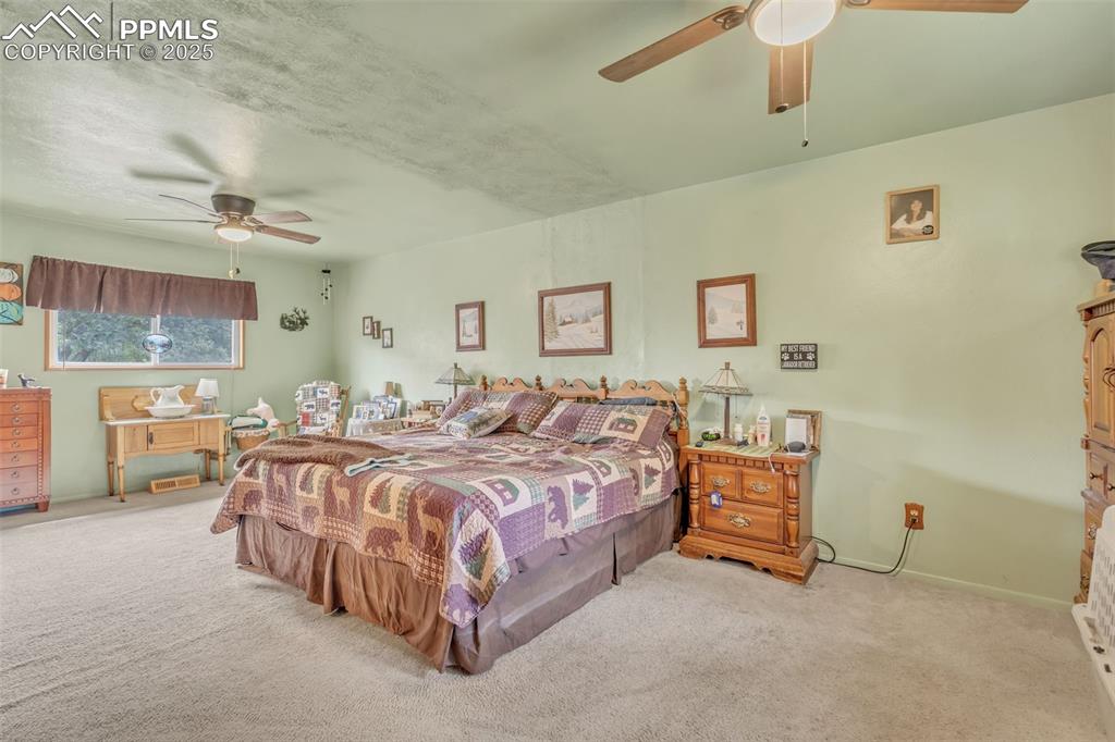 Image 19 of 49: Carpeted bedroom featuring a ceiling fan and baseboards