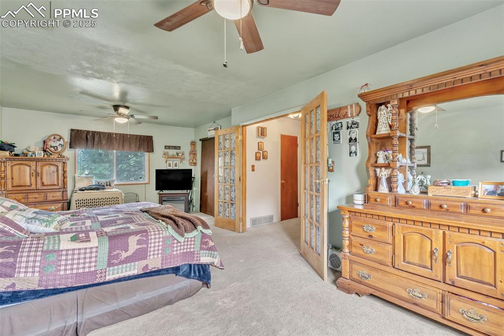 Image 23 of 49: Carpeted bedroom with a ceiling fan
