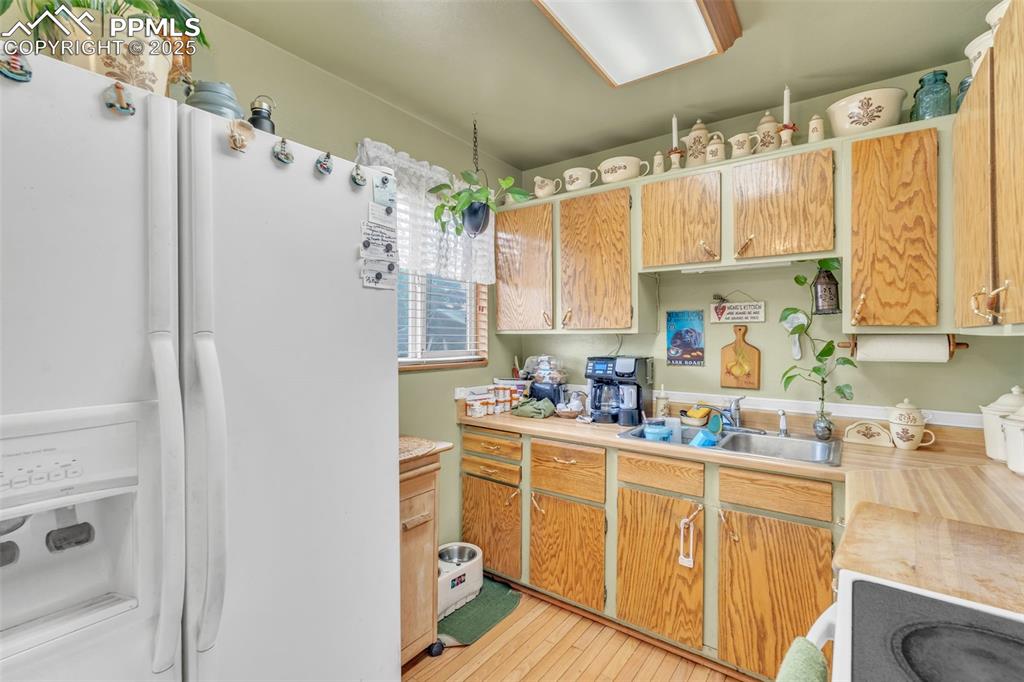 Image 24 of 49: Kitchen featuring white fridge with ice dispenser, light countertops, light