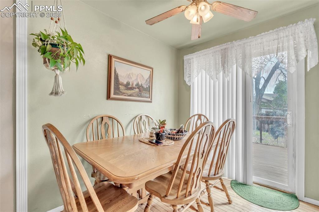 Image 29 of 49: Dining area with light wood finished floors and ceiling fan