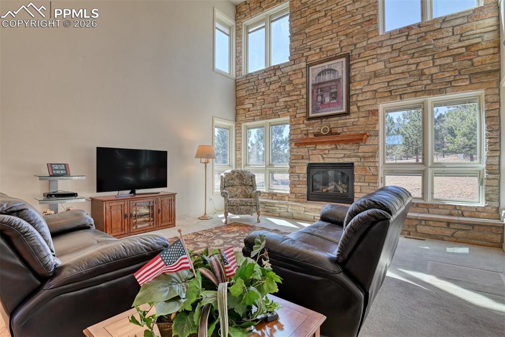 Image 14 of 47: Great room features a stone wall with gas fireplace