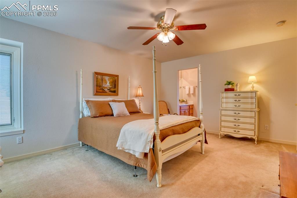 Image 28 of 47: Other view of bedroom with ceiling fan leading to the bathroom vanity. 