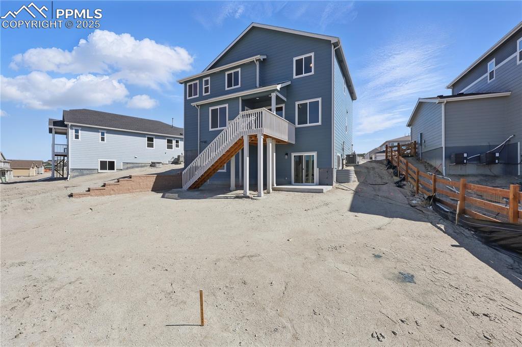Image 10 of 36: Back of property featuring fence, stairway, and a wooden deck