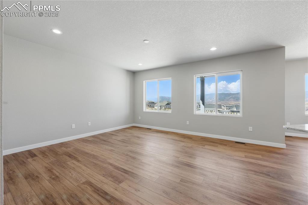 Image 13 of 36: Unfurnished room with a textured ceiling, recessed lighting, and light wood