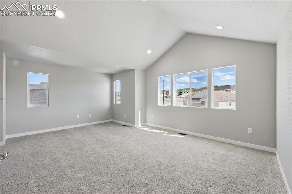 Image 20 of 36: Spare room with lofted ceiling, recessed lighting, baseboards, and carpet f