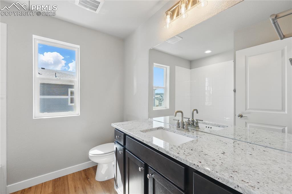 Image 30 of 36: Bathroom with visible vents, a healthy amount of sunlight, baseboards, wood