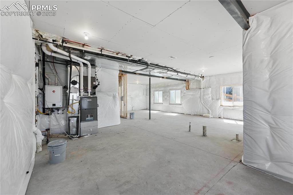 Image 33 of 36: Below grade area with tankless water heater