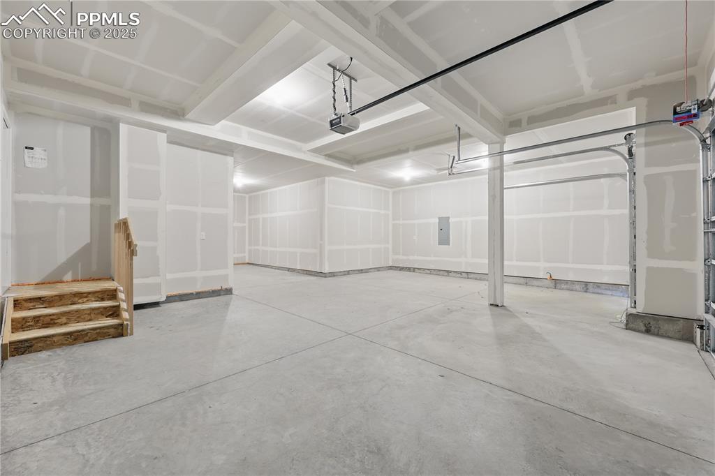 Image 35 of 36: Garage featuring electric panel and a garage door opener