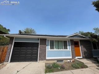 Caption: Ranch-style home with concrete driveway, a garage, and brick siding