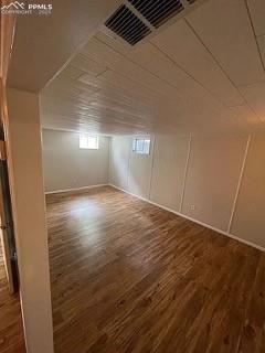 Image 24 of 25: Bonus room featuring a decorative wall and dark wood finished floors
