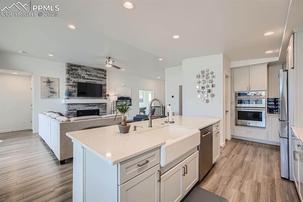 Image 10 of 31: Kitchen featuring recessed lighting, a fireplace, stainless steel appliance