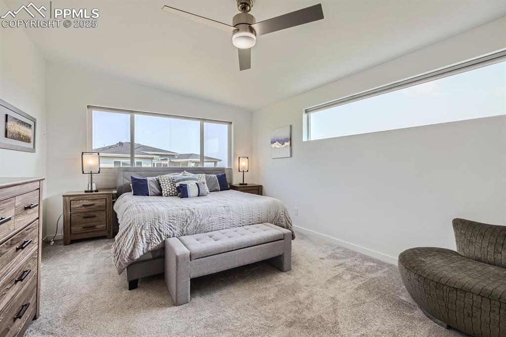 Image 12 of 31: Bedroom with light colored carpet and ceiling fan