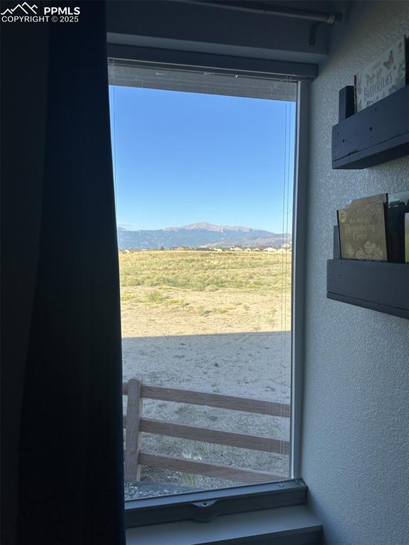 Image 17 of 31: Doorway to outside with a textured wall and a mountain view