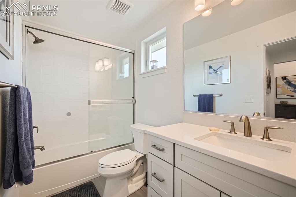 Image 18 of 31: Bathroom with bath / shower combo with glass door and vanity
