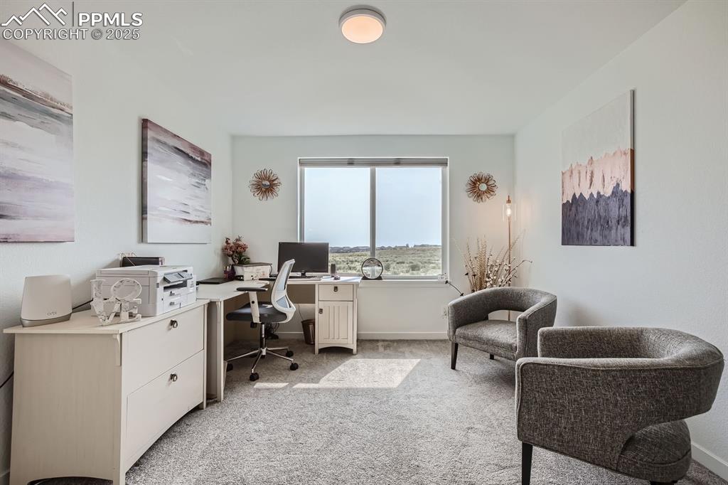 Image 19 of 31: Home office with light colored carpet and baseboards