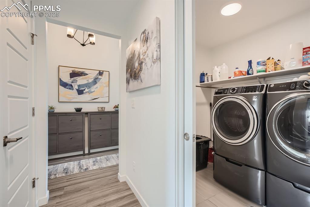 Image 28 of 31: Laundry area with washer and dryer and light wood-style floors