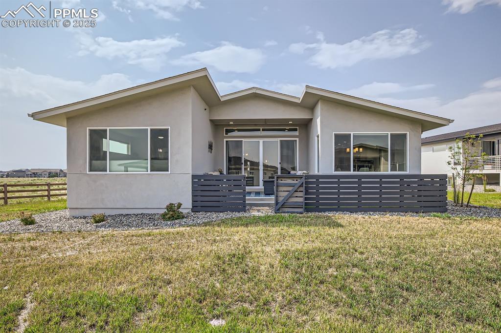 Image 31 of 31: View of front of house with stucco siding and a patio area