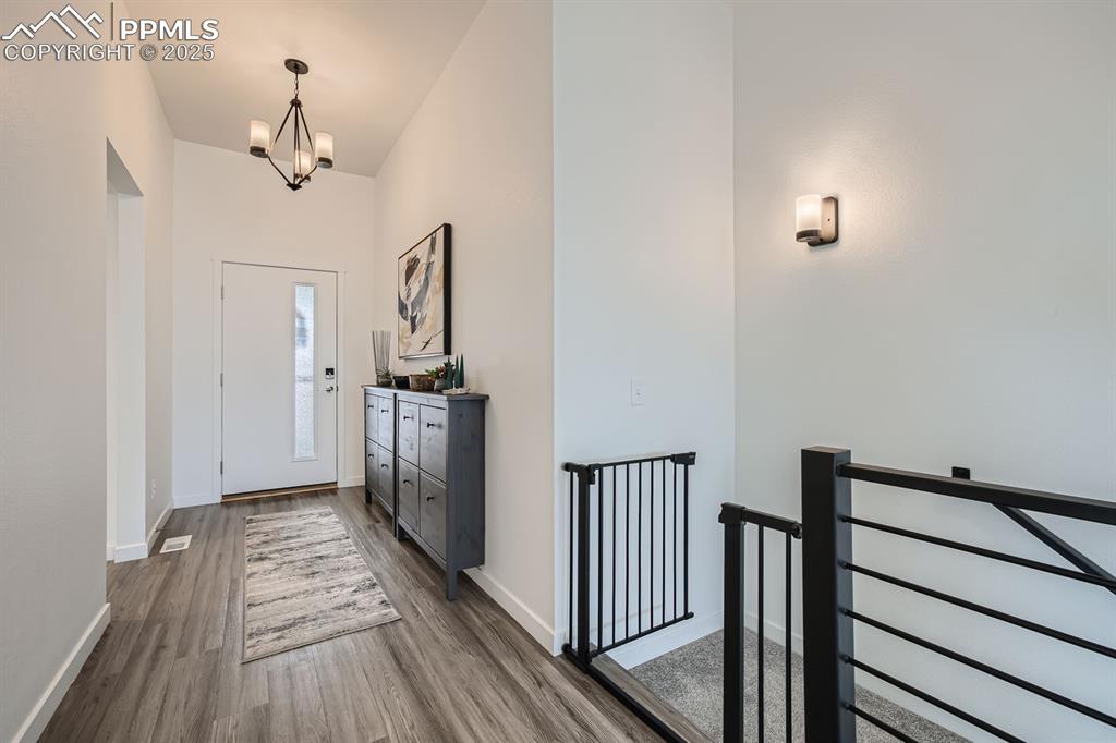 Image 4 of 31: Entryway with dark wood finished floors and a chandelier
