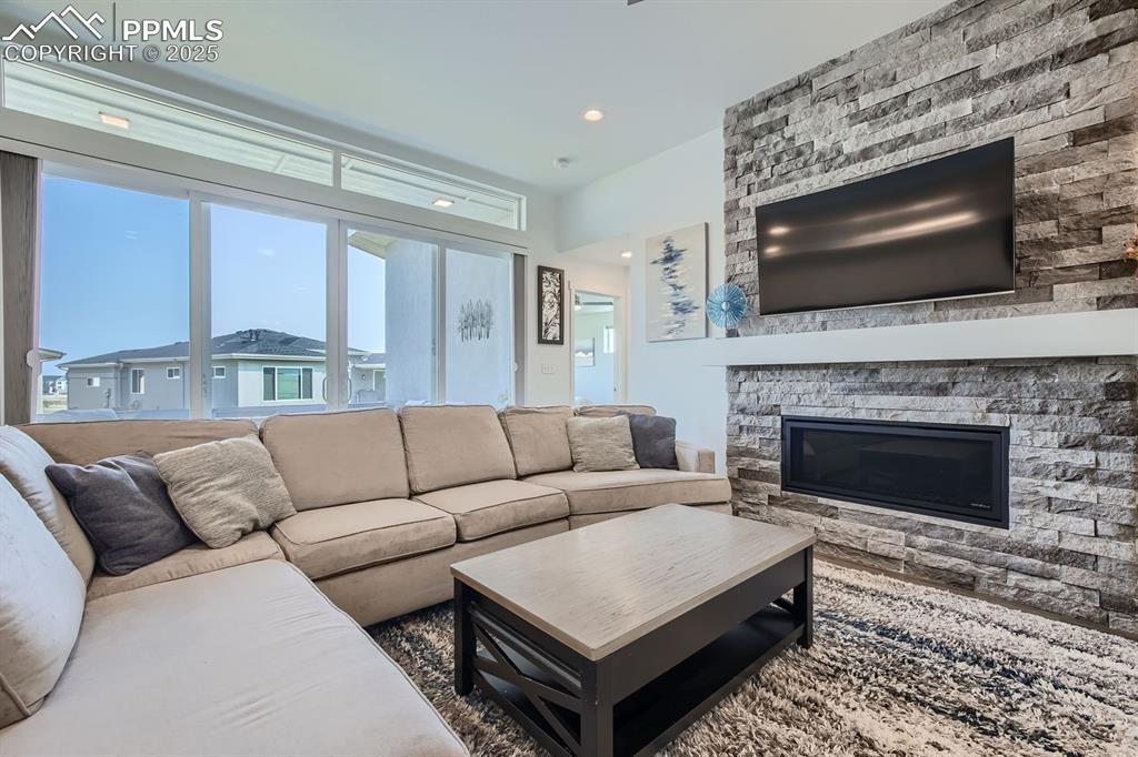 Image 5 of 31: Living area with a fireplace and recessed lighting