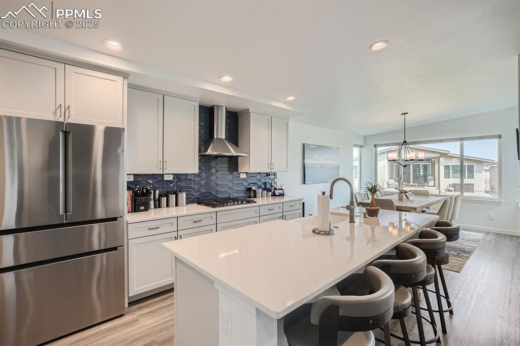 Image 7 of 31: Kitchen featuring appliances with stainless steel finishes, decorative back