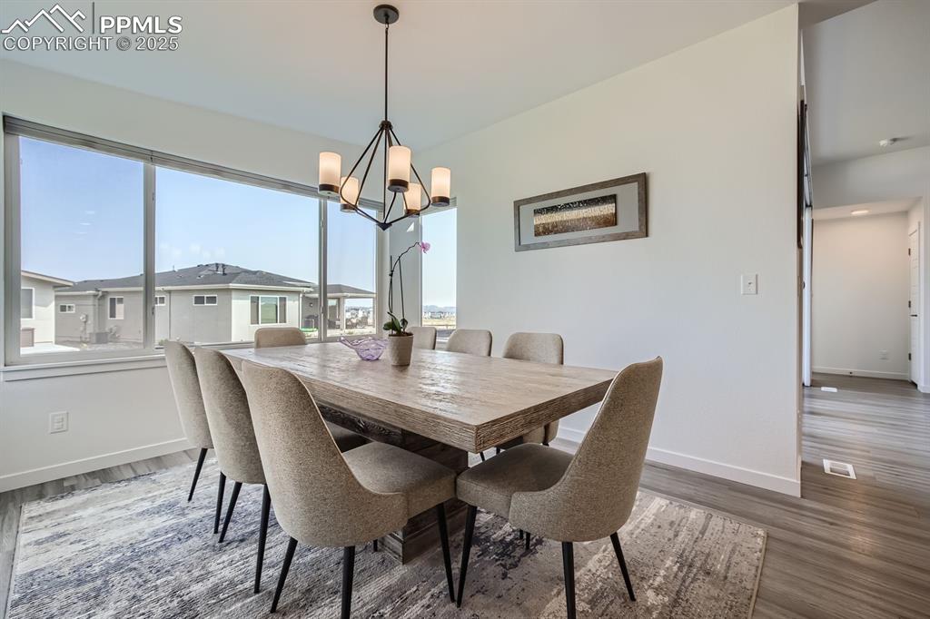 Image 9 of 31: Dining area with dark wood-style flooring and a chandelier