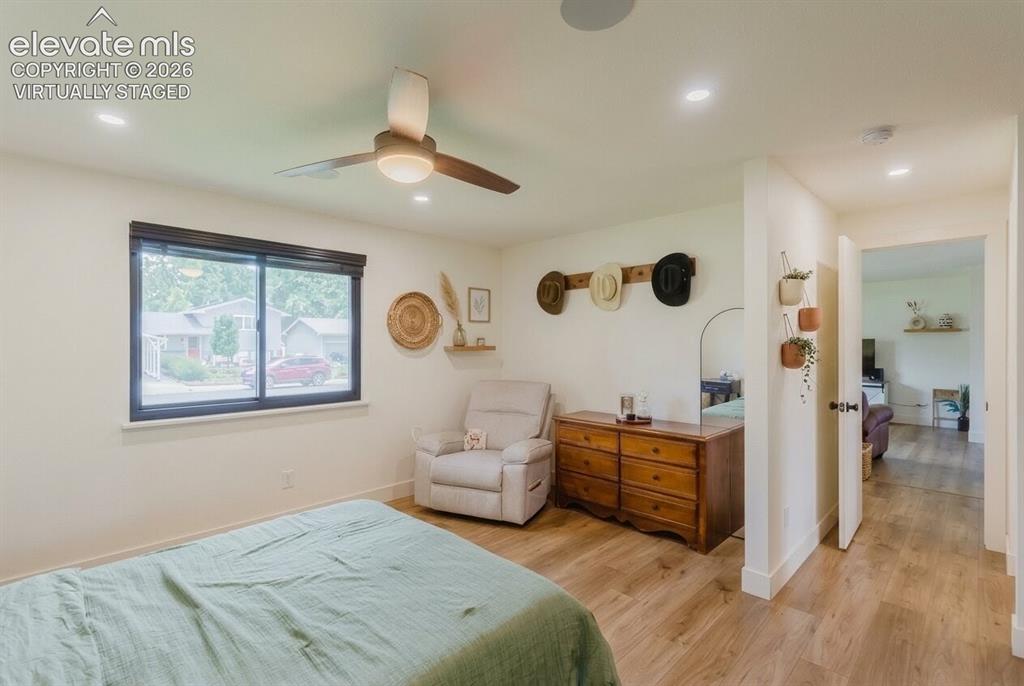 Image 12 of 49: Bedroom featuring wood-finish flooring, a window with dark trim, recessed l