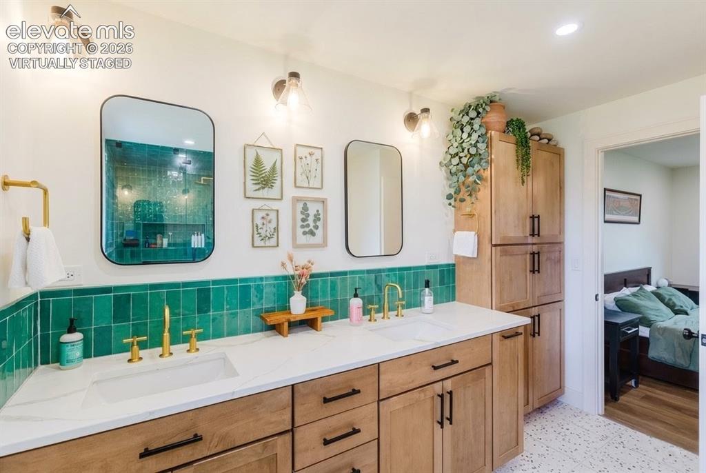 Image 13 of 49: Dual vanity with an integrated rectangular sink, gold-finish fixtures, and