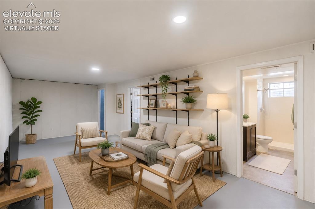 Image 17 of 49: Spacious living area featuring light gray flooring and a large area rug (v