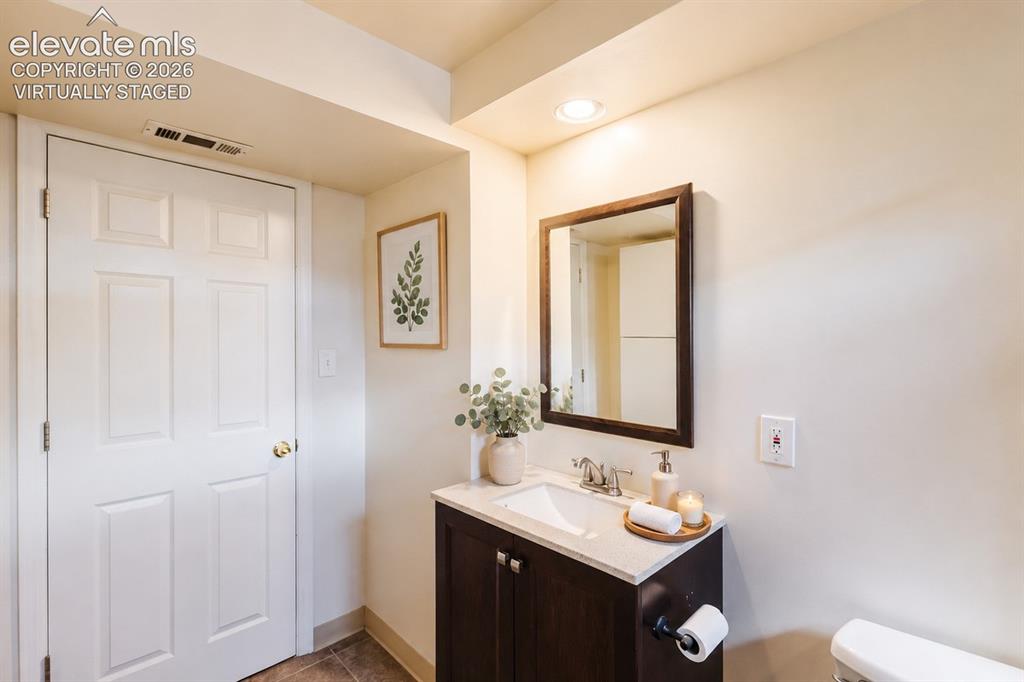 Image 19 of 49: Vanity with a light-colored countertop and dark wood-finish cabinetry (vir