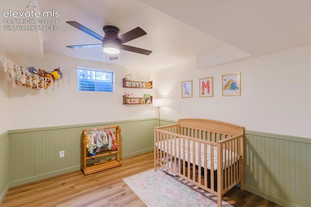Image 22 of 49: Room featuring wood-finish flooring, two-tone walls with lower beadboard pa