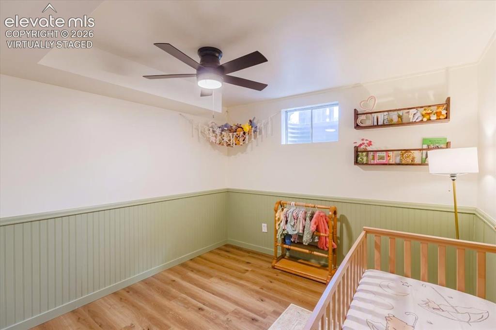 Image 23 of 49: Recessed lighting and a ceiling fan illuminate this room featuring wood-fin