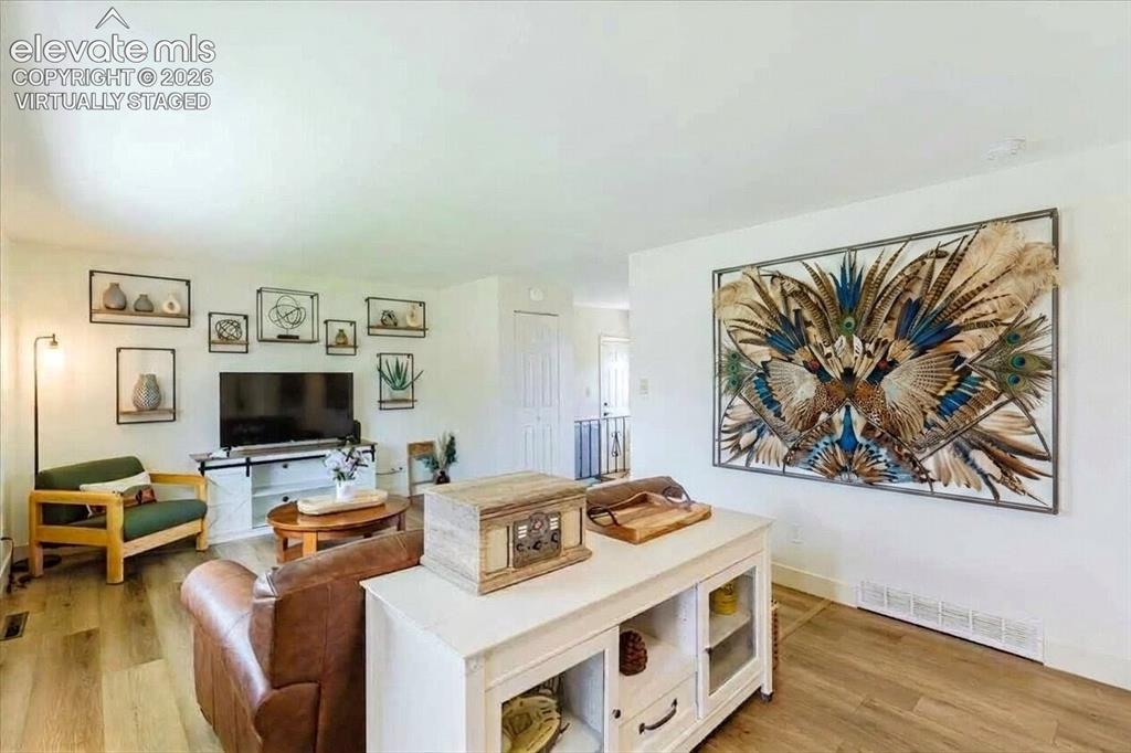 Image 3 of 49: Spacious room featuring wood-finish flooring, white walls, and a recessed c