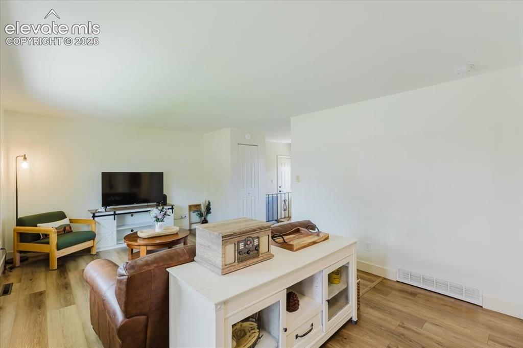 Image 30 of 49: Living area featuring wood-finish flooring, light-toned walls, and a white