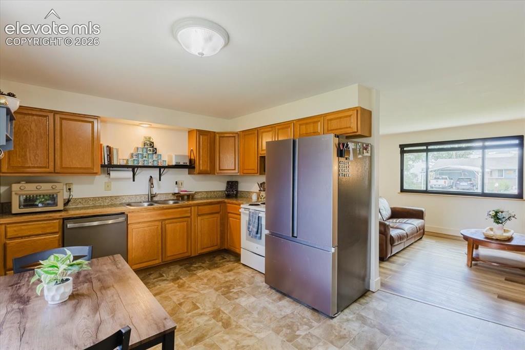 Image 34 of 49: Kitchen featuring wood cabinetry, granite-look countertops, stainless steel