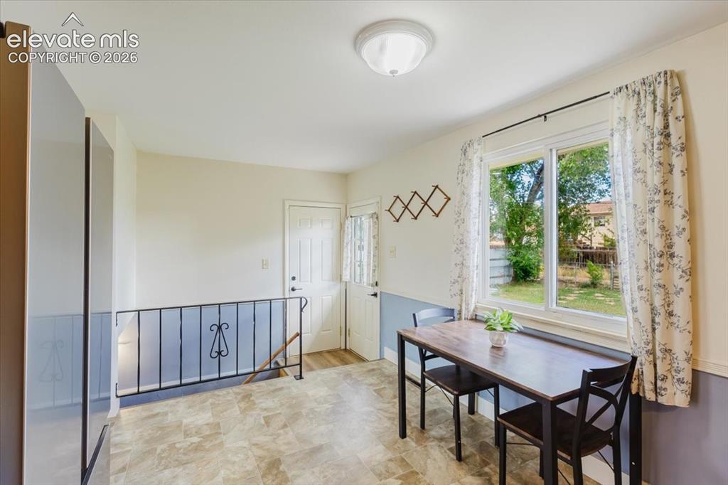 Image 35 of 49: Dining area featuring vinyl flooring, a large window with a backyard view,