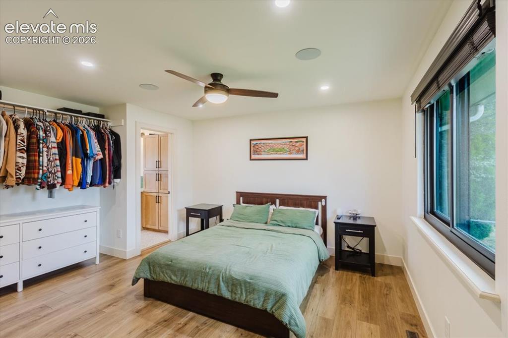 Image 39 of 49: Spacious bedroom featuring wood-finish flooring, recessed lighting, and a c