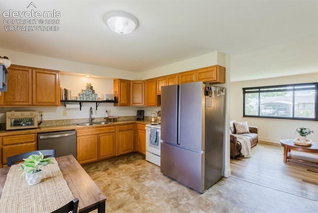 Image 7 of 49: Kitchen featuring wood cabinetry, stone-finish countertops, and a stainless