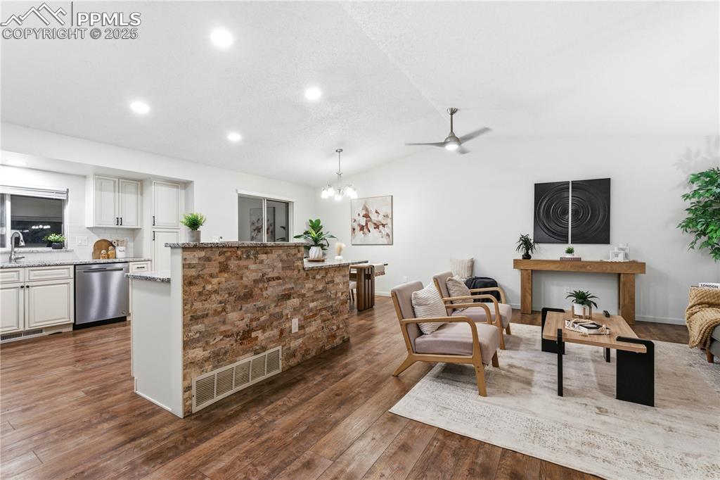 Image 10 of 31: Living room with dark wood-style floors, lofted ceiling, ceiling fan, reces